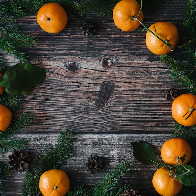 Decoratief Kerstmiskader van mandarijnen, spartakken, denneappels. Winter achtergrond met kopie ruimte