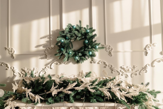 Decoraties voor het nieuwe jaar, een krans van dennentakken aan de muur. Kerst decoratieve krans in een gezellig huis