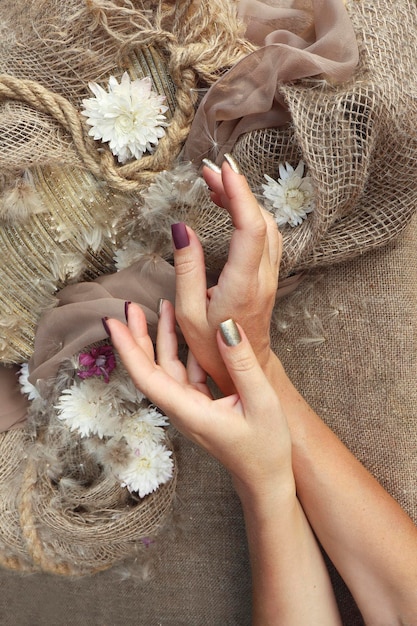 Decoratieve decoratie met bloemen op jute met vrouwelijke handen.