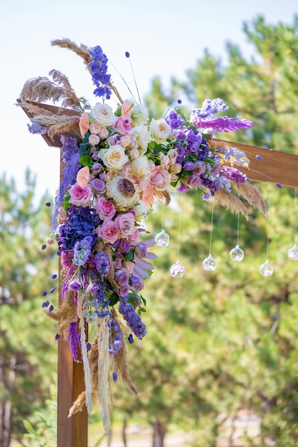 Decoratieve decoratie van de huwelijksboog met verse bloemen. Het houden van een huwelijksceremonie in de open lucht. Decoratiedetails