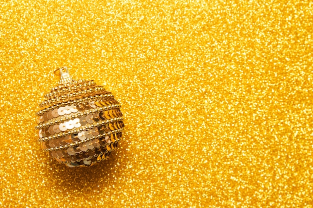 Decoratieve kerstbal op gouden glitter achtergrond