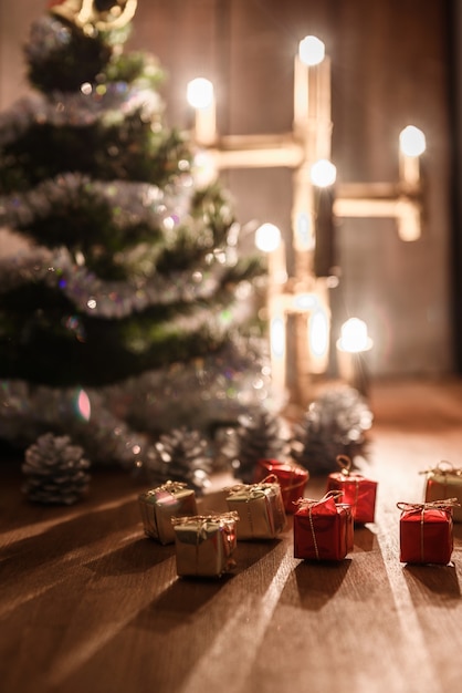 Decoratieve kerstboom is versierd met regen staat op de tafel met een verlichte lamp lichten