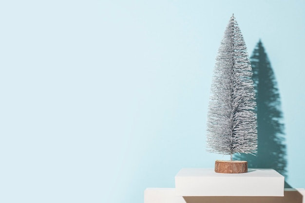 Decoratieve kerstboom op een blauwe achtergrond. harde schaduwen.