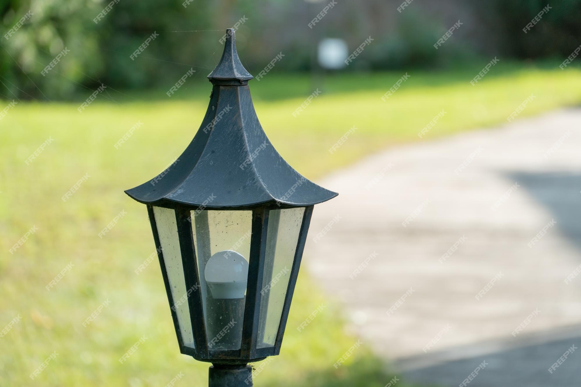 landbouw Wanorde beschaving Decoratieve kleine tuinlamp lantaarns op een bloembed en in een groene tuin  tuinontwerp een kleine lantaarn geeft gezelligheid en comfort in de tuin  van het huis | Premium Foto
