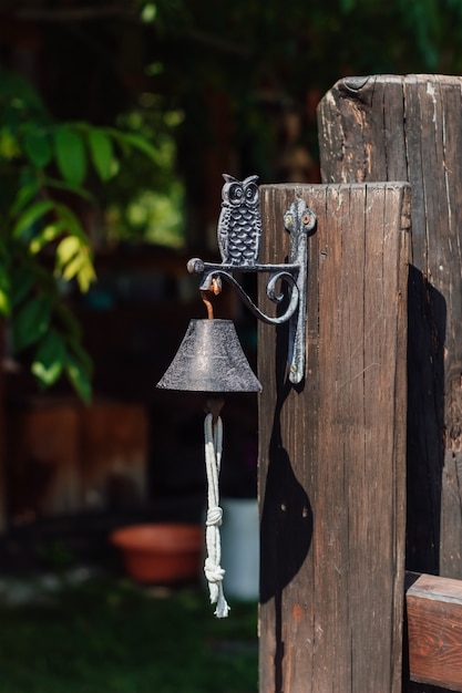 Decoratieve metalen bel met een uil bij de ingang van het huis Vertical