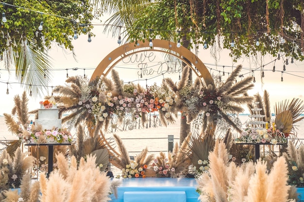 Decorating the arch with flowers and fabric for a wedding ceremony in nature Wedding Ceremony with flowers outside in the garden with hanging lights