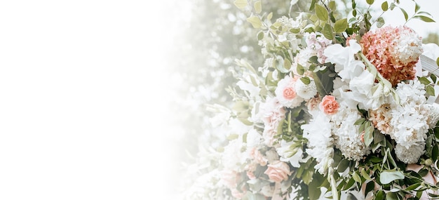 Decorare l'arco con fiori e tessuto per una cerimonia di matrimonio nella natura