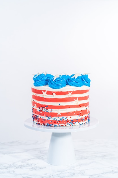 Photo decorating chocolate cake with white, red, and blue buttercream frosting for july 4th celebration.