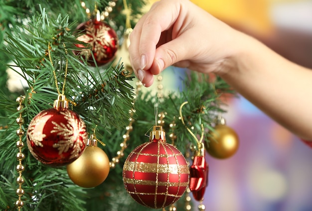 Decorating Christmas tree on bright background