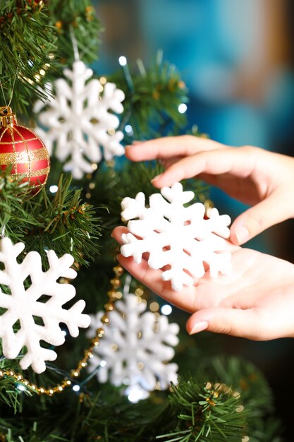 Decorating Christmas tree on bright background