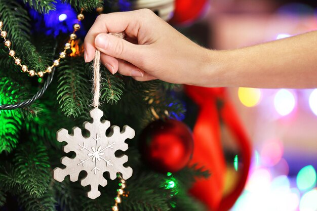 Decorating Christmas tree on bright background