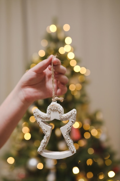 Decorating christmas tree holding christmas toy in a hand holiday christmas and new year family cele...