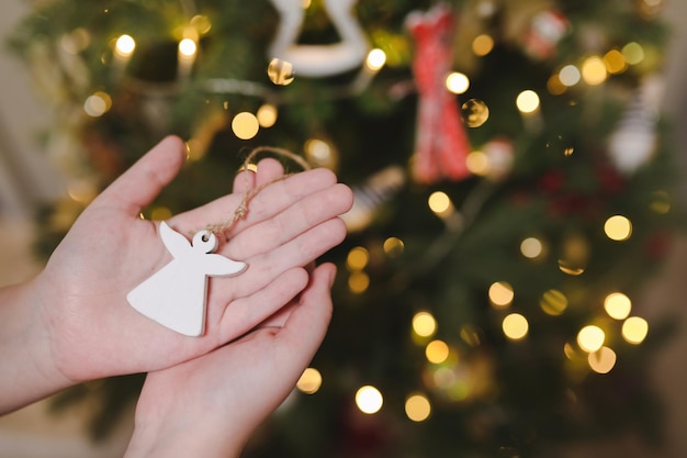 Decorating christmas tree holding christmas toy in a hand holiday christmas and new year family cele...