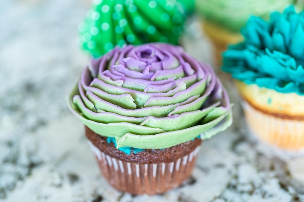 Decorating cupcakes with cactusshaped buttercream frosting