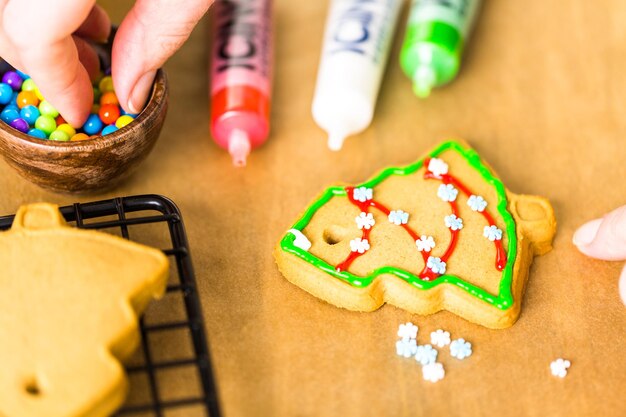 Decorating gingerbread cookies with royal icing and colorful candies.