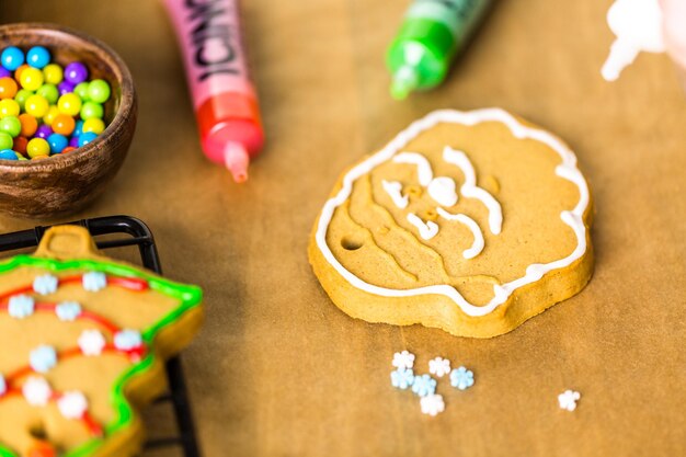 Decorating gingerbread cookies with royal icing and colorful candies.