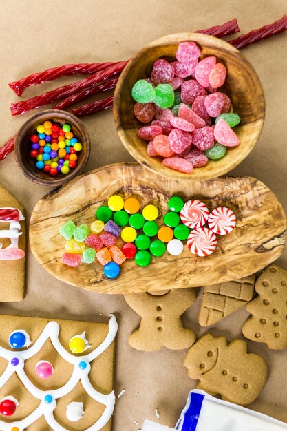 Decorating gingerbread house with royal icing and colorful candies.