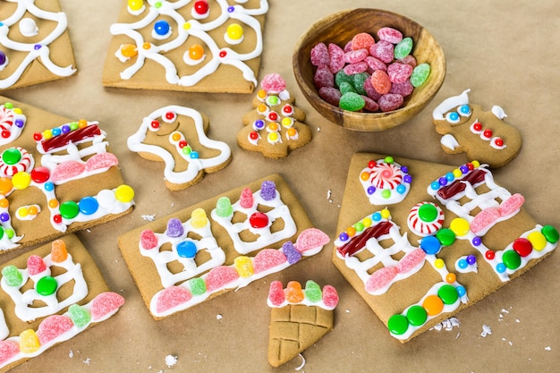 Decorating gingerbread house with royal icing and colorful candies.