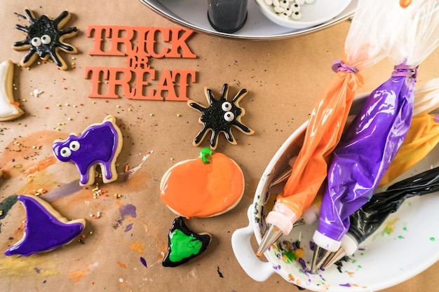 Photo decorating halloween sugar cookies with colorful royal icing.