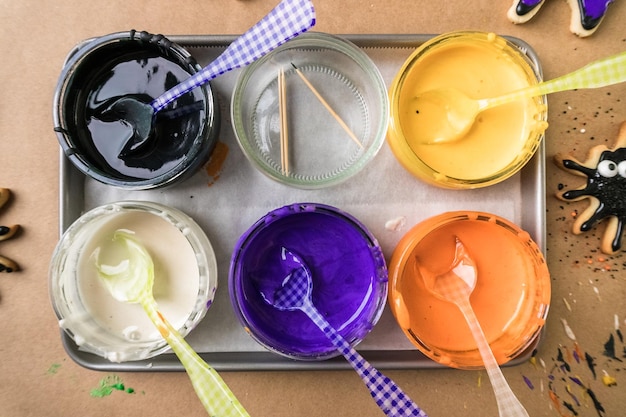 Photo decorating halloween sugar cookies with colorful royal icing.