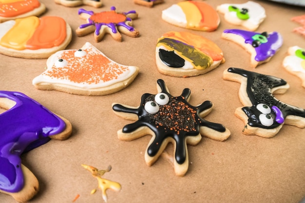 Decorating Halloween sugar cookies with colorful royal icing.