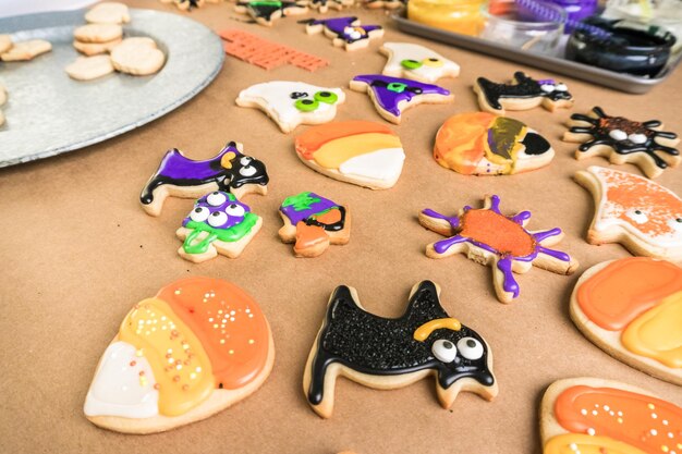 Decorating Halloween sugar cookies with colorful royal icing.