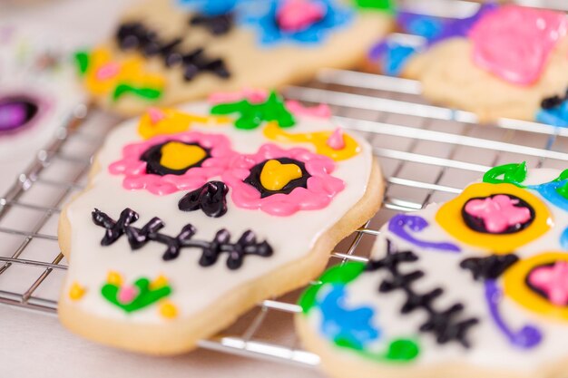 Decorating sugar cookies with royal icing for Dia de los Muertos holiday.