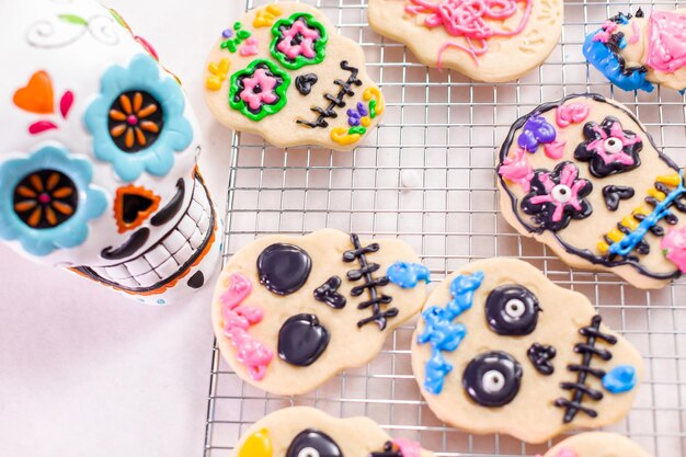 Decorating sugar cookies with royal icing for Dia de los Muertos holiday.