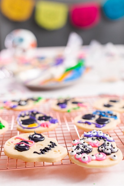 Decorare i biscotti di zucchero con glassa reale per la festa del dia de los muertos.