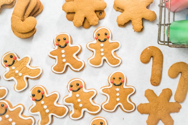 クリスマスのロイヤルアイシングで伝統的なジンジャーブレッドクッキーを飾ります。