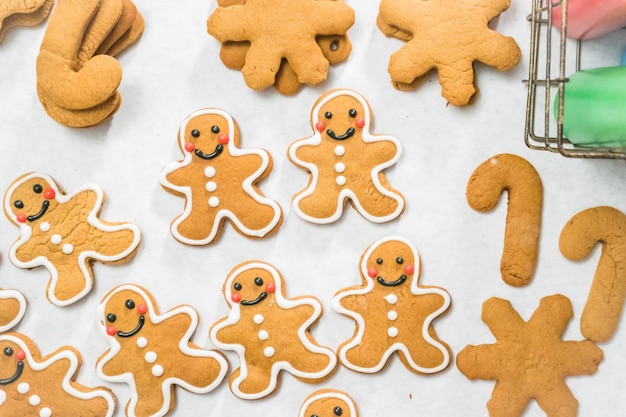 Decorating traditional gingerbread cookies with royal icing for Christmas.