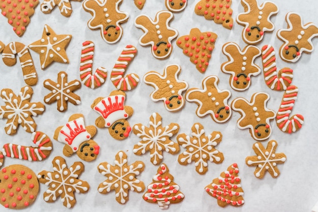 Decorating traditional gingerbread cookies with royal icing for Christmas.