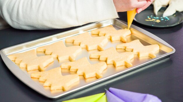 Decorating unicorn sugar cookies with multi-color royal icing.