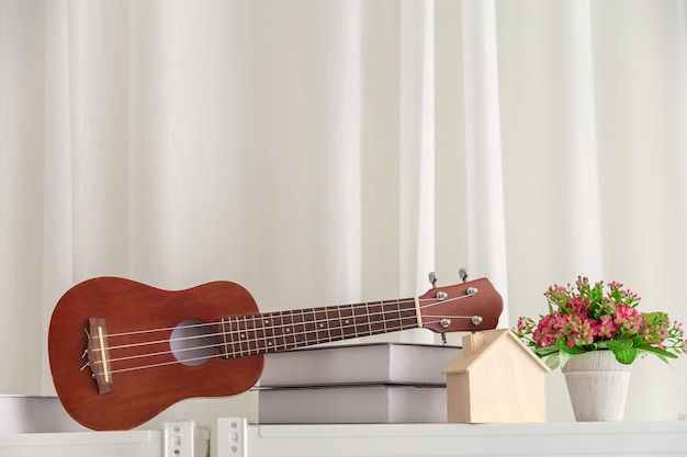 Decorazione in camera da letto con mini chitarra e libro con fiore.