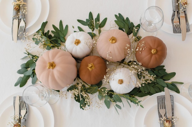 Decoration in boho style Pumpkins on the table with eucalyptus and gypsophila Stylish table decora