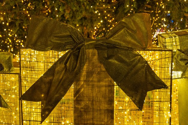 Decoration for christmas holidays. golden gift box under christmas tree at city square concept