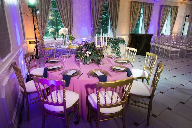 Decoration of the festive dinner with rose flowers on the wedding table in the interior of the restaurant. Decorated table for celebration.