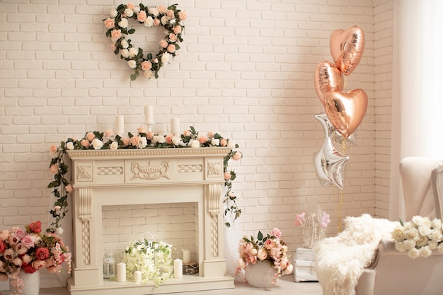 Decoration of the fireplace with flowers in a bright interior Festive decoration with helium, balloons