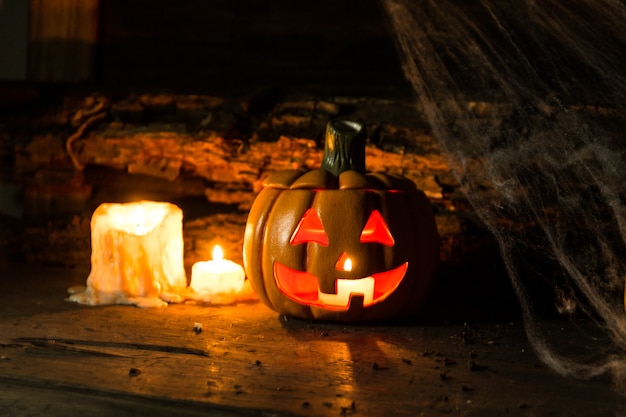 素朴な木の上のカボチャ、クモ、キャンドルでハロウィーンのお祝いのための装飾