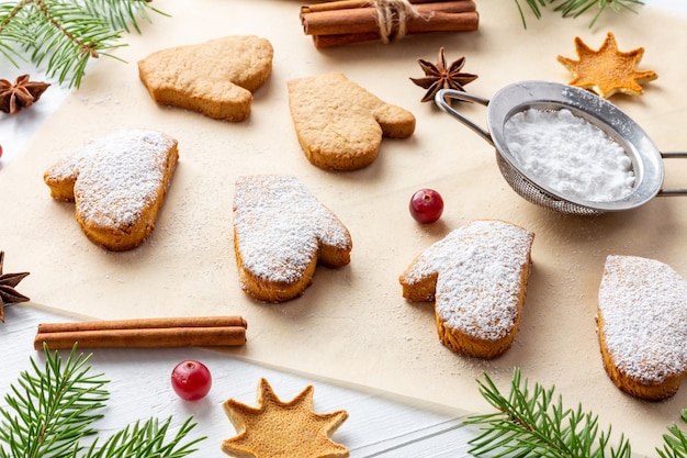 Decoration process of Christmas biscuits on baking paper with powdered sugar