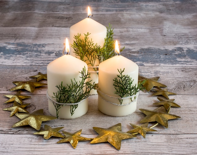 Decoration of three candles burning with green branches