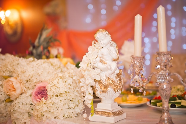 Decoration of the wedding table with a plaster statue of an angel at a sol