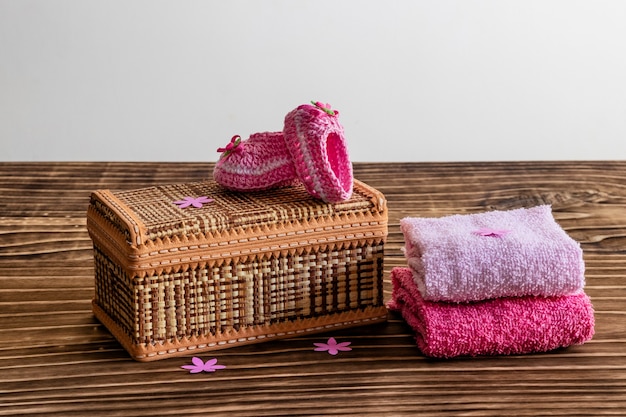 Decoration with pink baby shoe, wooden background, space for text