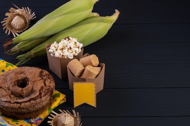 Decorazioni e cibi della festa junina su tavolo di legno nero