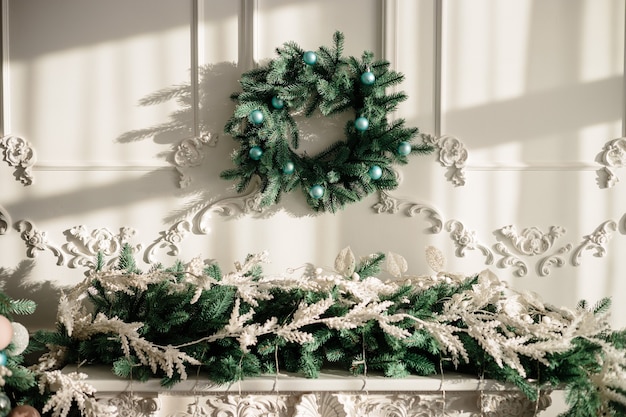 Decorations for the new year, a wreath of fir branches on the wall. Christmas decorative wreath in a cozy home