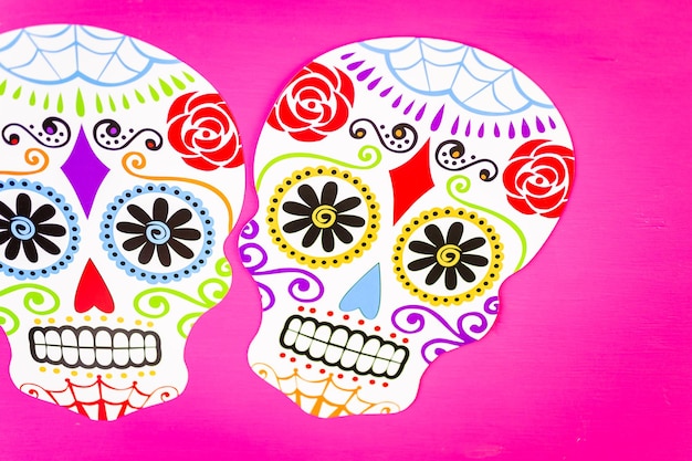 Decorations for traditional Mexican holiday Day of the Dead on a pink background.