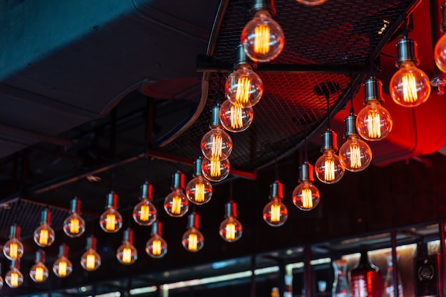 Decorative antique Edison style light bulbs with black ceiling in background.