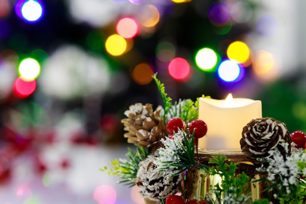 Decorative background with red berries and burning candle for Christmas