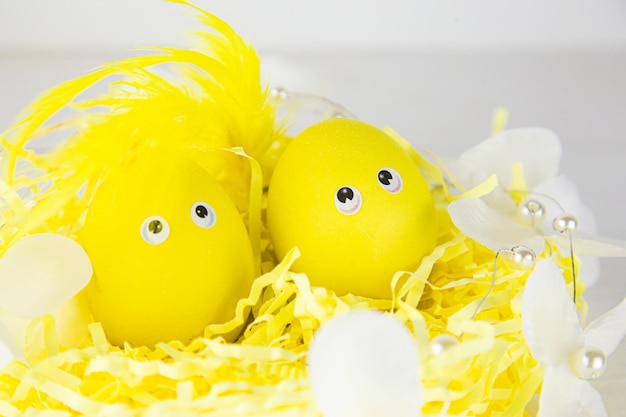 Decorative basket with yellow eggs decorated with feathers in the sun