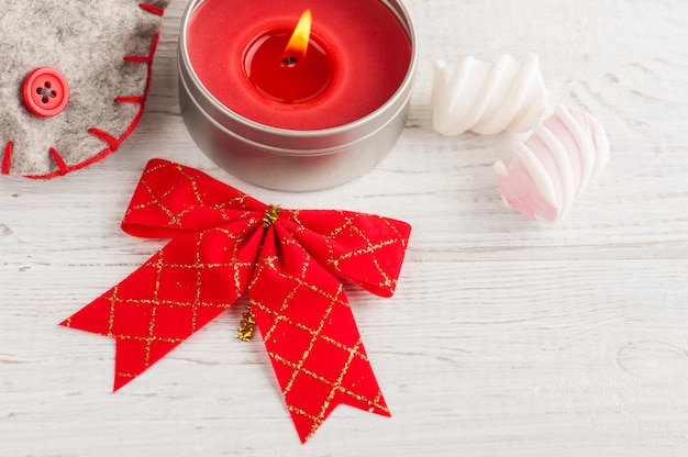 Decorative boot, bow and red lit candle